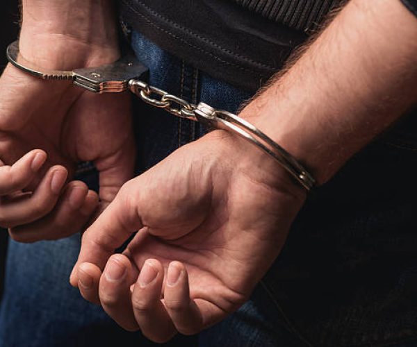 Close up of male hands in bracelets behind back
