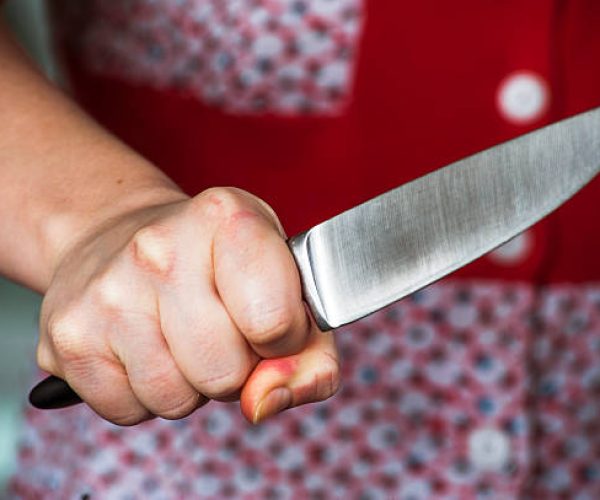 Woman hand holding big knife. Aggressive woman.